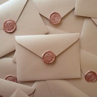 Розовые перламутровые конверты с сургучом.